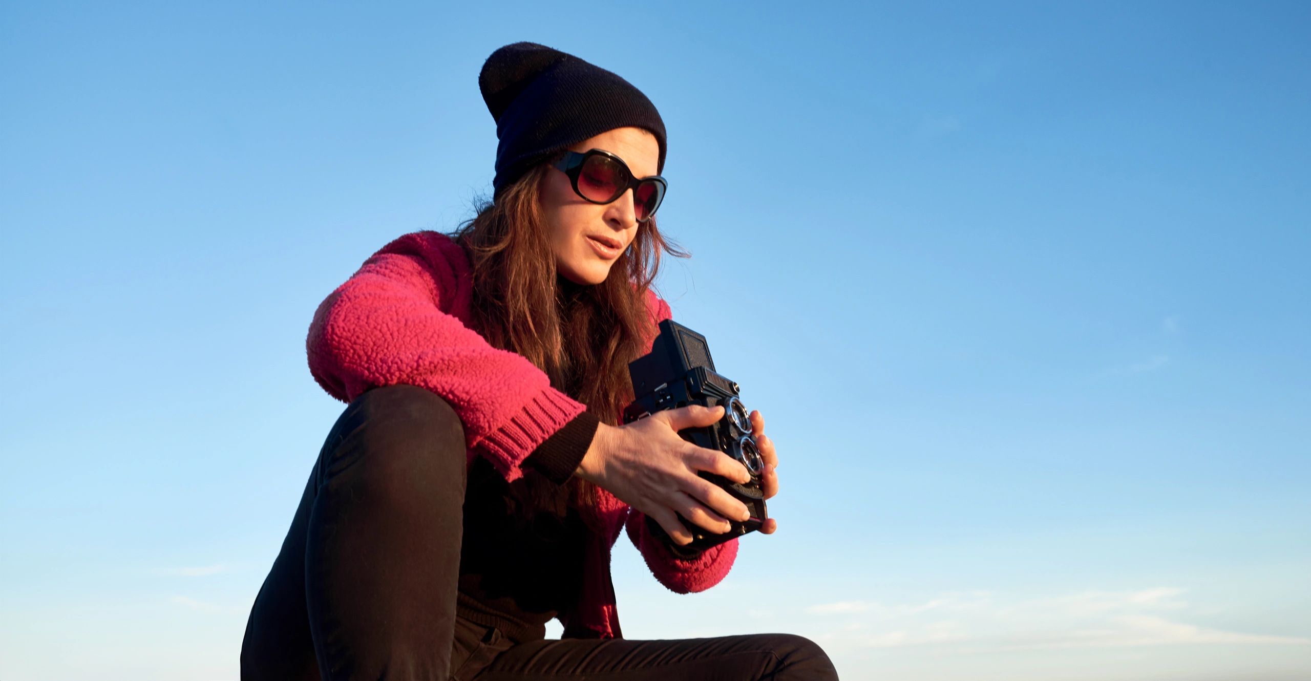 Photographer shooting with a vintage camera under a blue sky