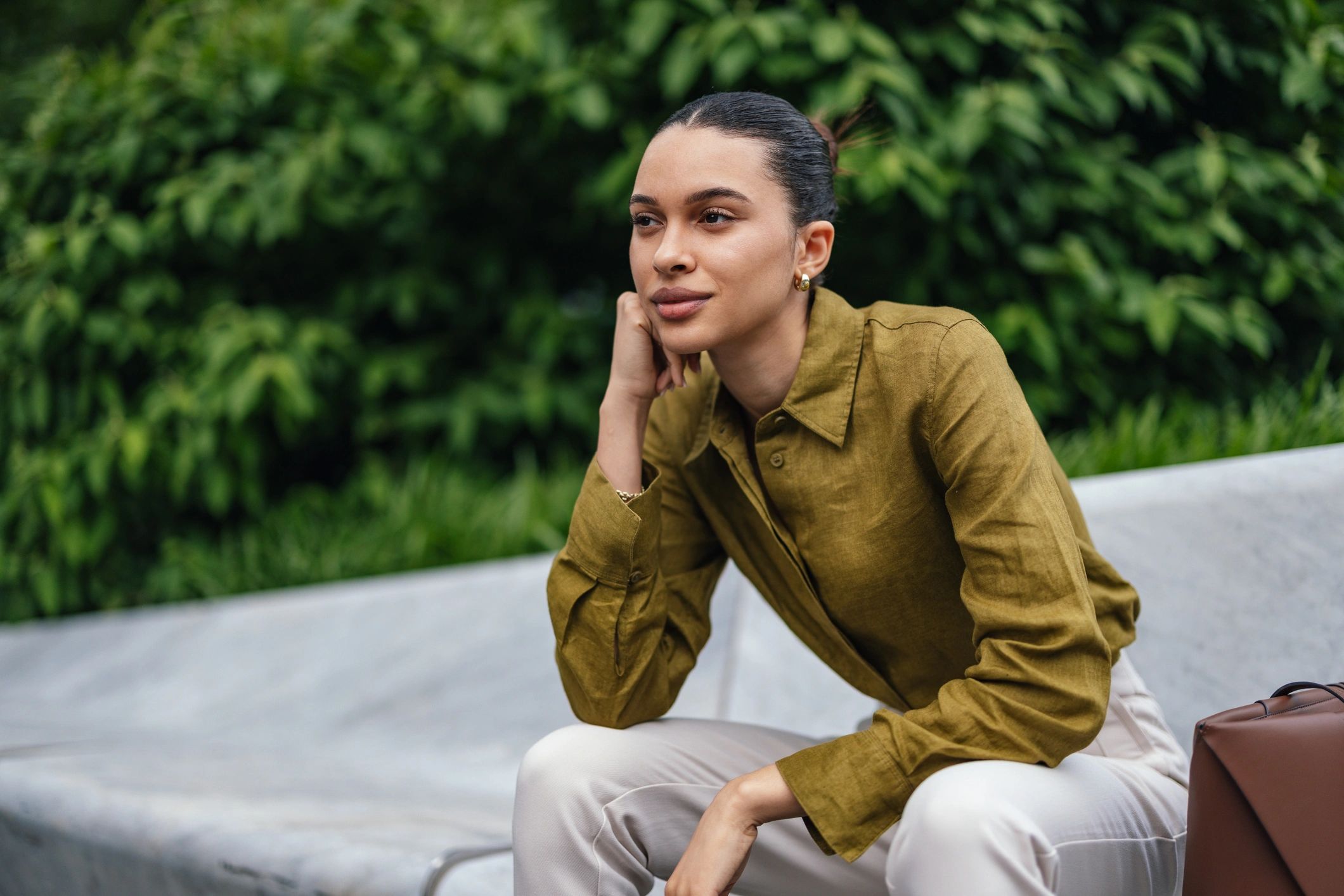 Thoughtful business woman outdoors on a bench